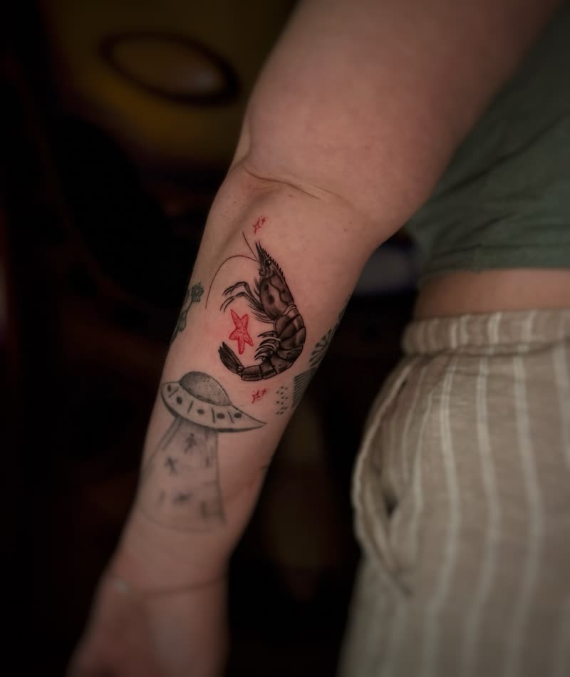 Small shrimp and starfish tattoo on an inner arm
